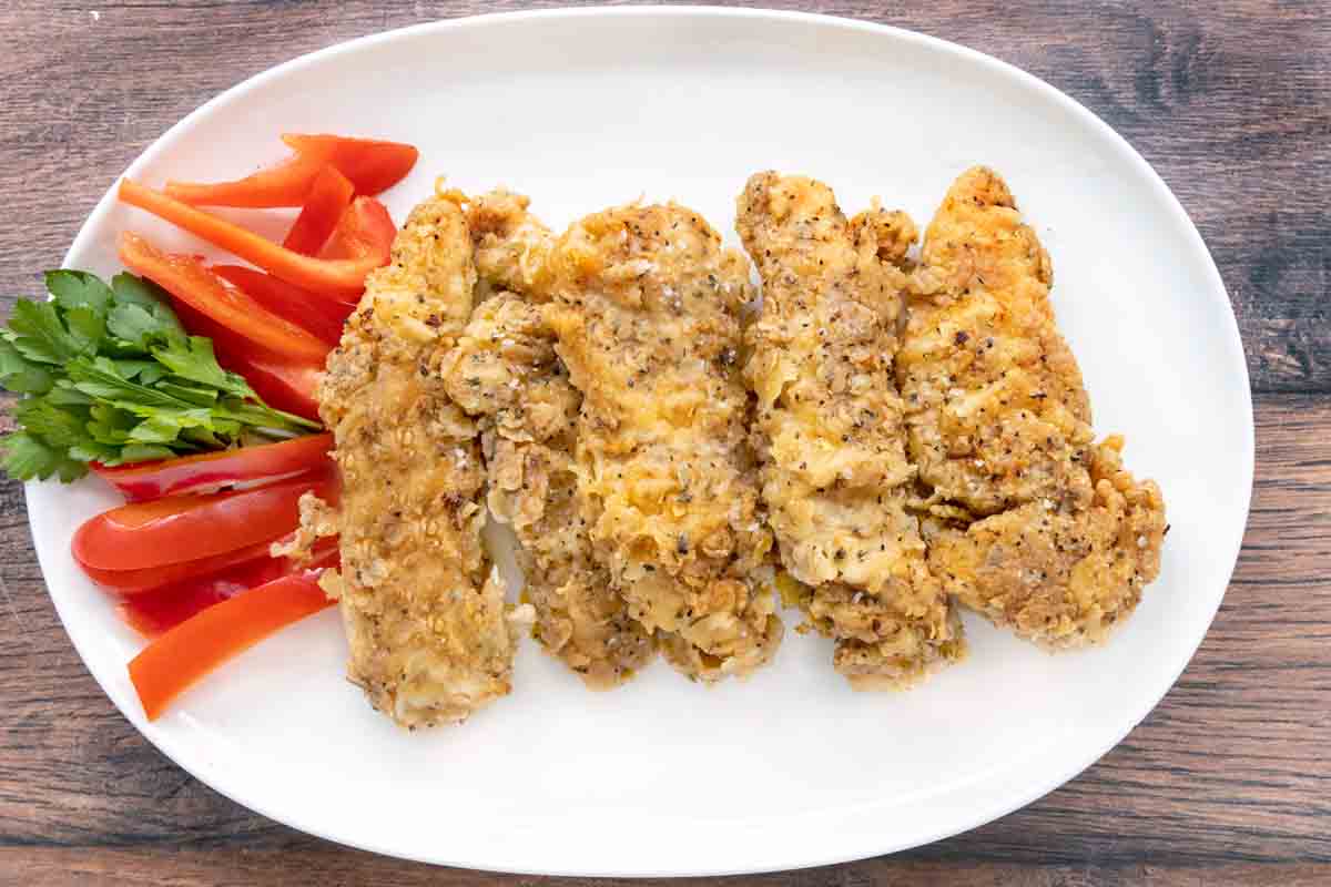 Spicy Fried Chicken Tenders on a white platter.