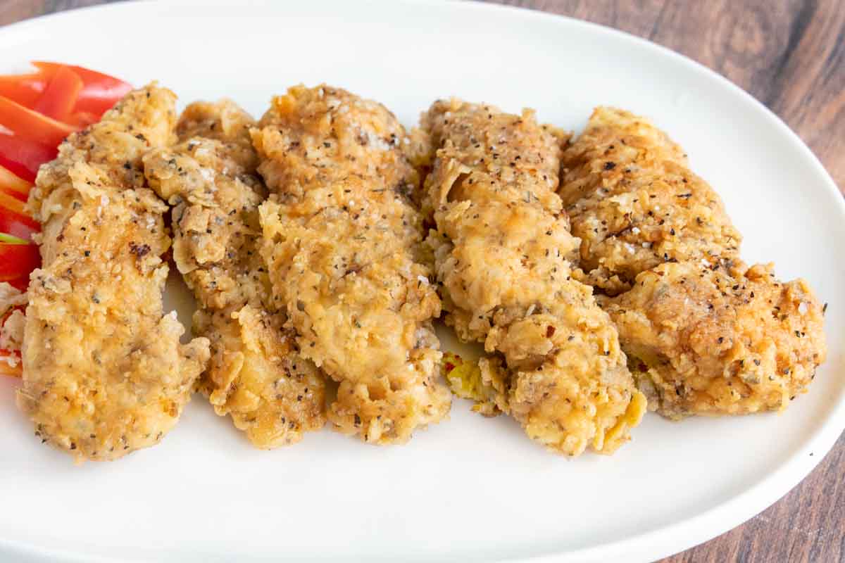 Spicy Fried Chicken Tenders on a white platter.