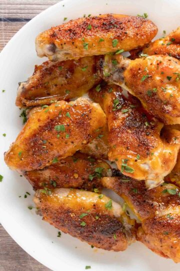 Honey Sriracha Chicken Wings on a white platter.