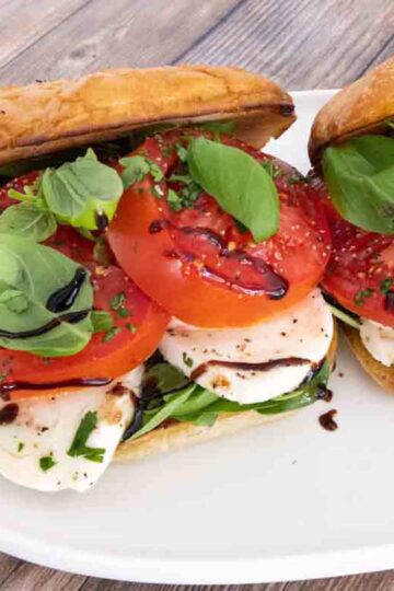 A plate with two caprese sandwiches on it.