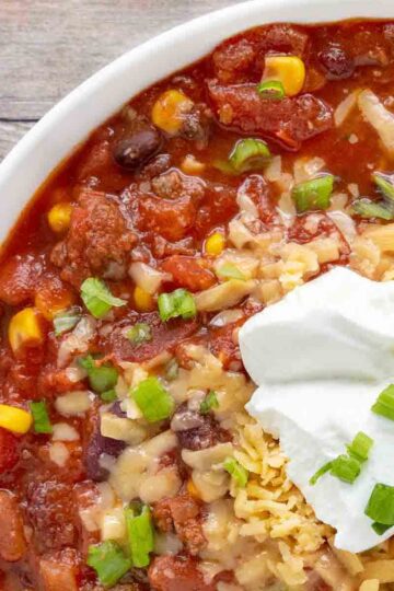 Bowl of chilli topped with sour cream and chives.