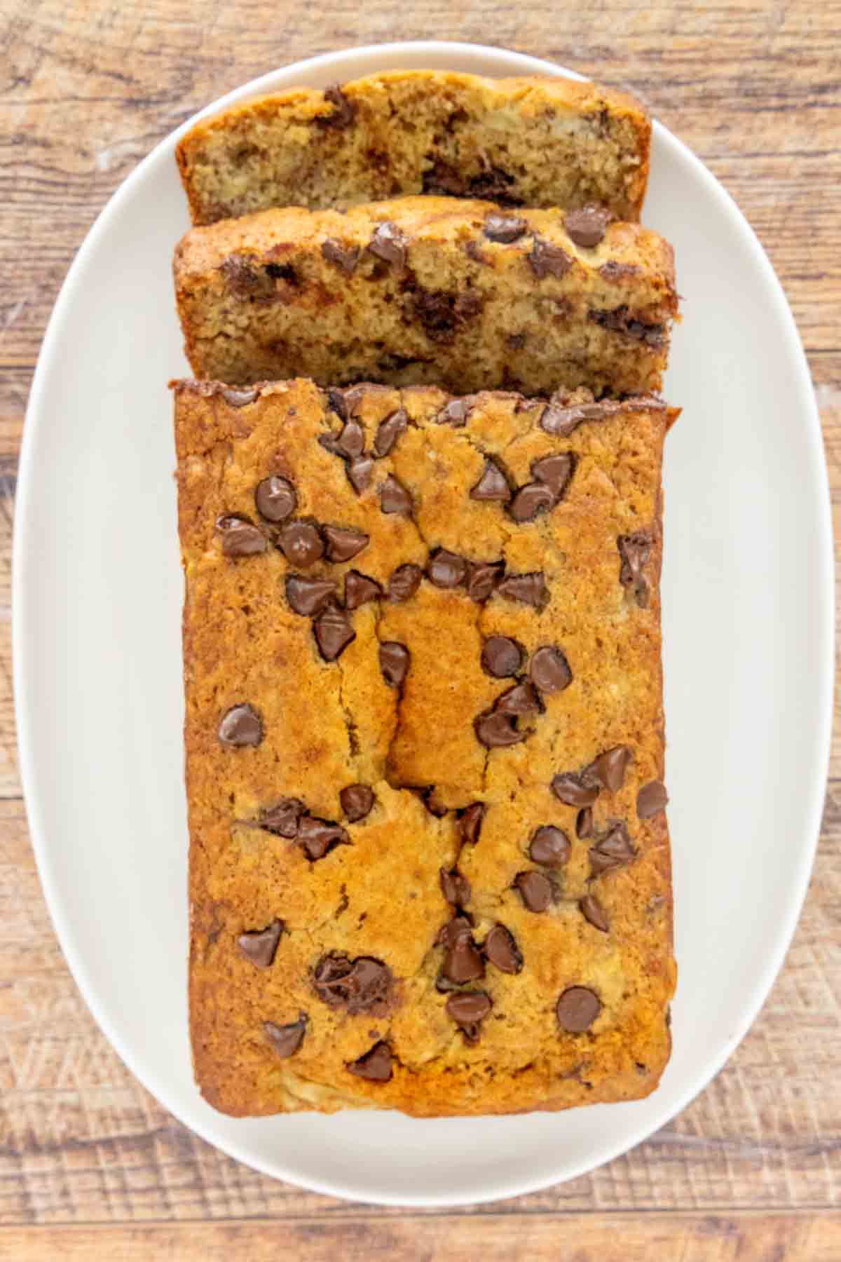 Chocolate Chip Banana Bread loaf, sliced, on a plate.