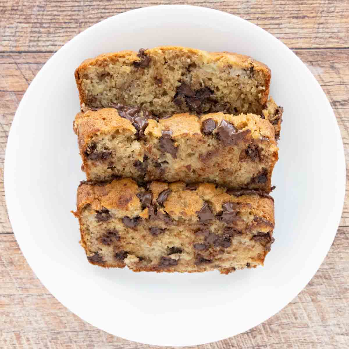 Chocolate Chip Banana Bread loaf, sliced, on a plate.
