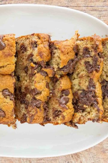 Chocolate Chip Banana Bread loaf, sliced, on a plate.