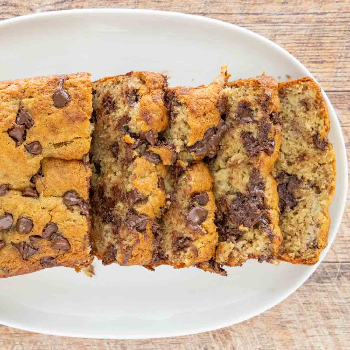 Chocolate Chip Banana Bread loaf, sliced, on a plate.
